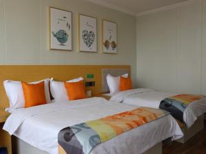 una camera con 2 letti arancioni e bianchi di Shell Suzhou Chinese Medicine Hospital Hotel a Suzhou