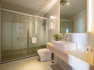a bathroom with a sink and a toilet and a shower at GreenTree Inn Changzhou Xixiasu Town Express Hotel in Luoxi