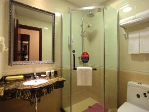 La salle de bains est pourvue d'un lavabo et d'une douche en verre. dans l'établissement GreenTree Inn Hefei Railway Station Baima Phase III Baowen Business Building Express Hotel, à Hefei