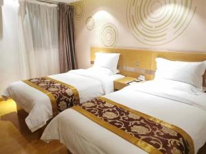 a hotel room with two beds and a window at GreenTree Xining Chengzhong Area Dongguan Street Street Hotel in Xining