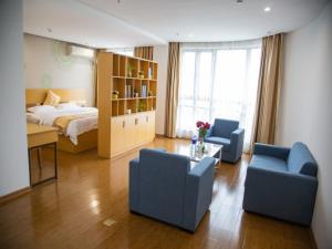 a bedroom with a bed and two blue chairs at GreenTree Inn Cixi Zhouxiang Town Jiayue Plaza Business Hotel in Cixi +8 photos