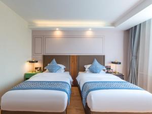 Postel nebo postele na pokoji v ubytování Gme Fuyang Guangming South Road Hotel