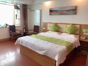a bedroom with a large bed with green pillows at GreenTree Inn ShanDong Jinan Railway Station Provincial Hospital Jinger Road Express Hotel in Jinan