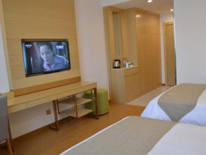 a hotel room with a television and a bed at GreenTree Inn Huaian Xuyi Royal Garden Express Hotel in Shiliying +29 photos