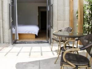 a patio with a table and chairs and a bed at GreenTree Inn Anqing Duxiu Avenue Greenland Metropolis Express Hotel in Anqing
