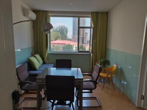 een woonkamer met een tafel en stoelen en een raam bij Shell Taiyuan Xiaodian District Shanxi Hospital Hotel in Taiyuan