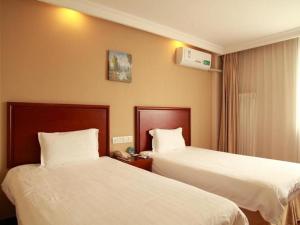 a hotel room with two beds with white sheets at GreenTree Inn Beijing Xisanqi Bridge Business Hotel in Changping