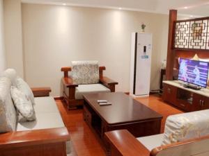 a living room with a couch and a refrigerator at GreenTree Inn ShanXi ChangZhi Bus Passenger Station XiHuan Road Business Hotel in Changzhi