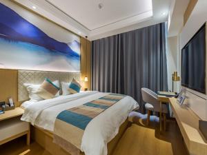 a hotel room with a large bed and a desk at GreenTree Eastern Xuzhou High Speed Railway Station West Exit Station Hotel in Xuzhou