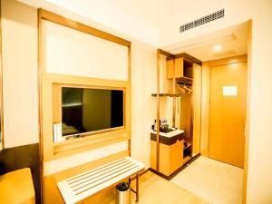 une chambre avec un banc et une fenêtre dans l'établissement GreenTree Inn Xuzhou Economic Development Zone Da Miaozhen Business Hotel, à Xuzhou