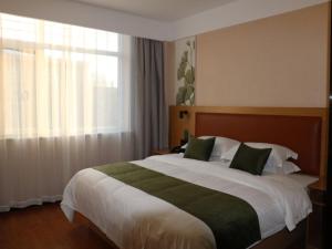 a bedroom with a large bed and a window at GreenTree Inn Hengshui Jingtai Avenue in Hengshui