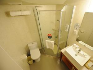 W łazience znajduje się prysznic, toaleta i umywalka. w obiekcie GreenTree Inn ShanDong YanTai Development Zone International Airport Shell Hotel w mieście Penglai