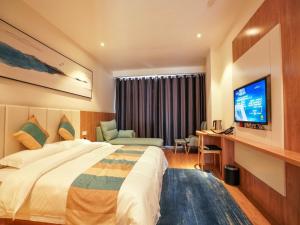 a hotel room with a bed and a television at VX Zibo Zhangdian District Jinjing Avenue Hotel in Zibo