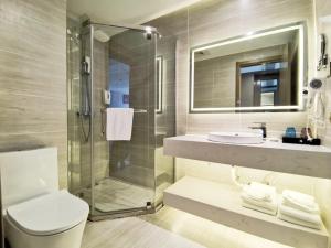 a bathroom with a shower and a toilet and a sink at Gya Taizhou Jingjiang City South Century Plaza Hotel in Jingjiang