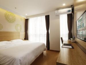 a bedroom with a large white bed and a window at GreenTree Inn Liaocheng Economic Development Zone Huitong Logistics Park Express Hotel in Liaocheng