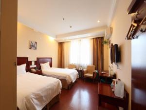 a hotel room with two beds and a television at GreenTree Inn Hefei Maanshan Road Qiupuhe Road Subway Station Business Hotel in Hefei