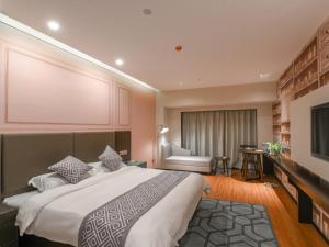 1 dormitorio con 1 cama grande y pantalla grande en GME Hefei Fuyang North Road Beicheng Hotel, en Hefei
