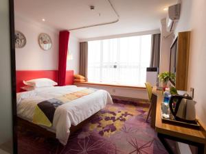 Säng eller sängar i ett rum på Shell Zhengzhou Zhongyuan Fota Hotel