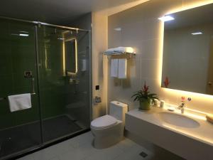 a bathroom with a shower and a toilet and a sink at GreenTree Inn Shaoxing Binhai New City Dongsen Commercial Square Hotel in Shaoxing