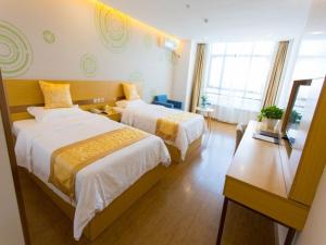 a hotel room with two beds and a window at GreenTree Inn Cixi Zhouxiang Town Jiayue Plaza Business Hotel in Cixi