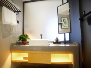 a bathroom with a sink and a mirror at GreenTree Inn Fuyang Exhibition Center Business Hotel in Fuyang