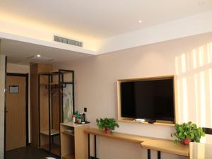 a living room with a large flat screen tv on the wall at GreenTree Inn Hengshui Jingtai Avenue in Hengshui