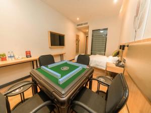 南京市にあるGreenTree Inn Nanjing Lukou Airportのテーブルと椅子と寝室のある部屋