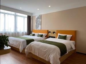 two beds in a hotel room with at GreenTree Inn Changzhou Zouqu Town Tai fu Times Square Zhenzhong Road Express Hotel in Changzhou