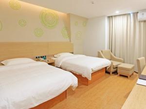 a hotel room with two beds and a chair at GreenTree Inn Anqing Duxiu Avenue Greenland Metropolis Express Hotel in Anqing