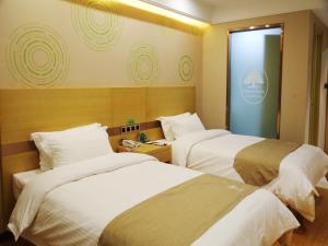 une chambre d'hôtel avec deux lits et une fenêtre dans l'établissement GreenTree Inn Hefei City Baohe DistrictGarden Avenue Express Hotel, à Hefei