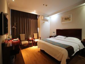 a hotel room with a large bed and a desk at GreenTree Inn JiangSu WuXi YangJian XiHu Road Express Hotel in Wuxi