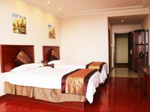 una camera d'albergo con due letti in una stanza di GreenTree Inn JiangSu WuXi YiXing East LongTan Road DongJiu Business Hotel a Yixing