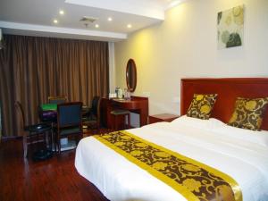 a hotel room with a large bed and a desk at GreenTree Inn Jiangsu Wuxi Jiangyin North Huancheng Road Walking Street Express Hotel in Jiangyin