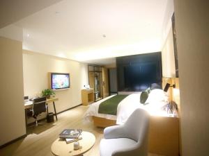 a hotel room with a bed and a desk at GreenTree Inn Fuyang Exhibition Center Business Hotel in Fuyang