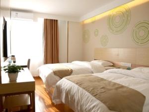 a hotel room with three beds and a table at GreenTree Inn Beijing Tongzhou District Yujiawu Technology park Express Hotel in Tongzhou