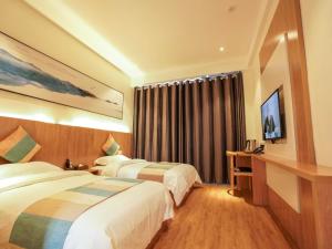 a hotel room with two beds and a window at VX Zibo Zhangdian District Jinjing Avenue Hotel in Zibo