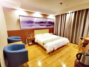 a hotel room with a bed and two blue chairs at GreenTree Alliance Changzhou Jintan District Dongmen Street Hotel Hotel in Changzhou +24 photos