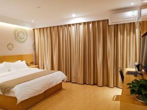 a bedroom with a bed and a window with curtains at GreenTree Inn Tangshan Qianxi Bus Terminal Express Hotel in Qian'an