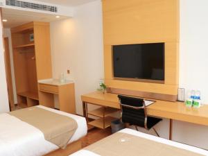 um quarto de hotel com uma secretária e uma televisão em GreenTree Inn Huangshi Huahu Development Zone Daquan Road Business Hotel em Huangshi