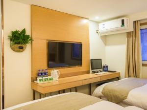 Habitación de hotel con 2 camas y escritorio con TV. en GreenTree Inn Beijing Dongcheng District Wangfujin South Luogu Lane Houhai Express Hotel, en Beijing