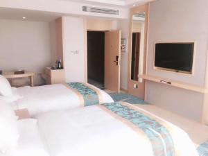 a hotel room with two beds and a flat screen tv at GreenTree Eastern Fuyang Yingdong District South Guoyang Road Hotel in Fuyang
