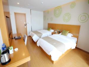 una camera d'albergo con due letti e una scrivania di GreenTree Inn Suzhou South zhongshan Road Shangyi Bus Station Express Hotel a Suzhou