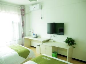 - une chambre avec un lit et une télévision murale dans l'établissement Shell Langfang Bazhou Museum Yingbin Dongdao Hotel, à Langfang
