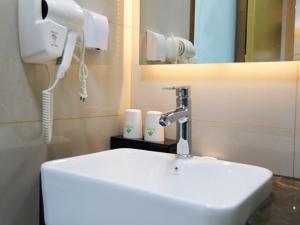 une salle de bain avec un lavabo blanc et un téléphone dans l'établissement GreenTree Inn Hefei City Baohe DistrictGarden Avenue Express Hotel, à Hefei