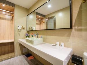 baño con lavabo y espejo grande en GreenTree Alliance Kunming Beijing Road Linyuqiao Subway Station Hotel, en Kunming