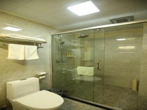a bathroom with a toilet and a glass shower at GreenTree Alliance Shandong Linyi Mengyin Xincheng road Hotel in Mengyin