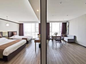 a hotel room with two beds and a dining room at Gya Taizhou Jingjiang City South Century Plaza Hotel in Jingjiang +22 photos