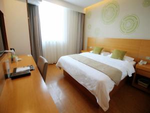 una camera d'albergo con un letto grande e una scrivania di GreenTree Inn Suzhou South zhongshan Road Shangyi Bus Station Express Hotel a Suzhou