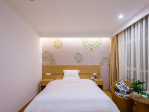 Un dormitorio con una gran cama blanca y una ventana en GreenTree Inn Anshun Xihang Road Business Hotel, en Anshun