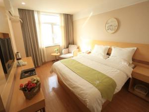 a bedroom with a large bed and a television at Green Alliance Chengde City Shuangqiao District Summer Resort Hotel in Chengde